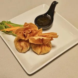 a plate of dumplings with dipping sauce