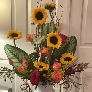 Modern funeral arrangement with bold sunflowers