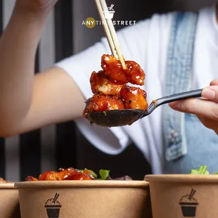 a woman holding chopsticks over a bowl of food