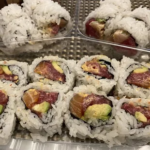 a variety of sushi rolls in plastic containers