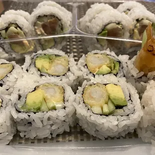 a plate of sushi rolls with avocado