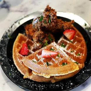 a plate of waffles and fried chicken