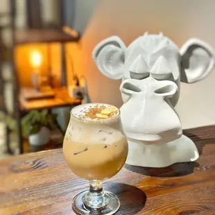 MONKEY BUSINESS LATTE (ICED ONLY) A honey latte topped w/ banana cream. honey drizzle, cinnamon powder, &amp; Banana Chip