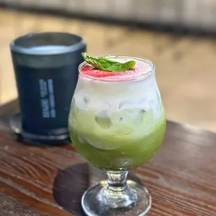 BLUEBERRY BABOON A creamy blueberry matcha topped with sweet cream, blueberry powder, and mint leaf