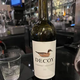 a bottle of decoy wine and a glass of water