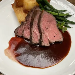 Beef with crispy potatoes and green beans served during wedding reception.