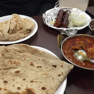 Kebab with onions, rumali roti, chicken tikka, and goat karahi