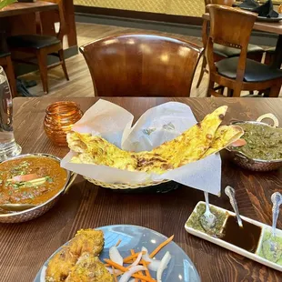 Garlic naan front and center. Chicken Kashmiri on the right. Punjabi lamb curry to the left.