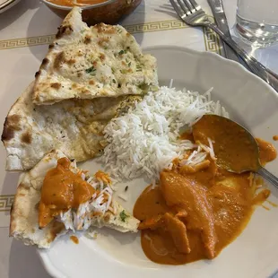 Butter chicken with rice, garlic naan, and paneer kulcha naan