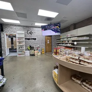 Half closed restroom right next to Open groceries and Kitchen with flies all around