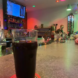 a glass of soda sitting on a bar