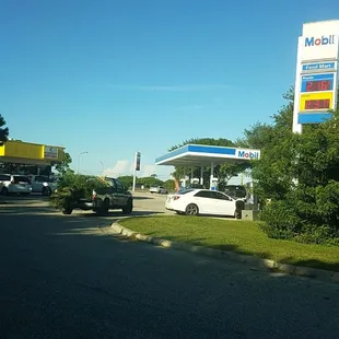 a white car parked in front of a gas station