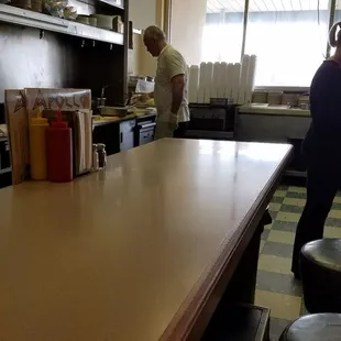 The man behind counter bangs out the grub!