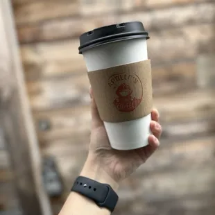 a hand holding a coffee cup