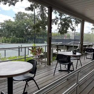 tables and chairs on a deck overlooking a river