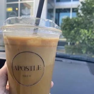 a hand holding a cup of iced coffee