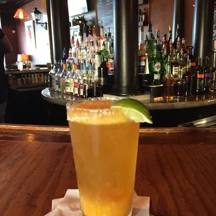 a glass of orange juice with a lime garnish