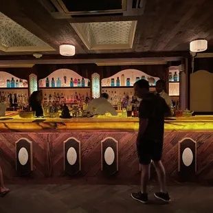 two people standing at a bar