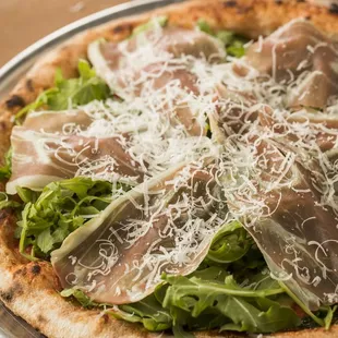 Prosciutto Pizza: Tomato sauce, Mozzarella, local arugula, and shaved Grana Padano cheese.