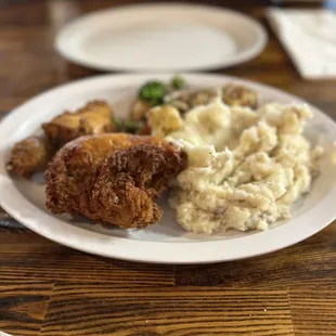 a plate of fried chicken, mashed potatoes and broccoli