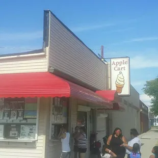 a group of people standing outside of an ice cream shop