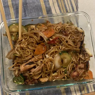 a glass dish of noodles with chopsticks