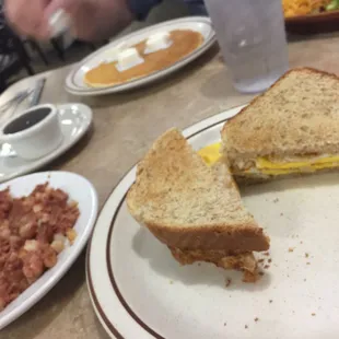 Fried egg sandwich and corned beef hash and pan cake.