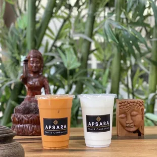 two cups of coffee and a buddha statue