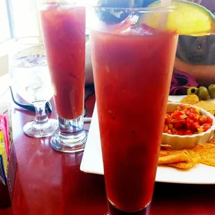 two glasses of juice and a plate of chips