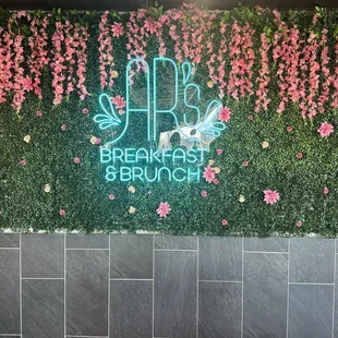 a green wall with pink flowers