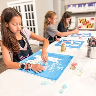 Kids receiving step-by-step instruction during a canvas pillow birthday party event.