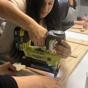 Using the staple gun to put together the wood planks