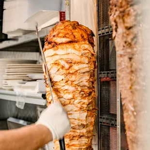 a man holding a large skewer of meat