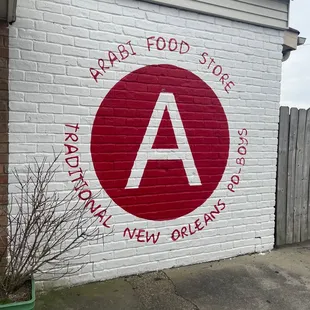 a red and white sign on a brick wall