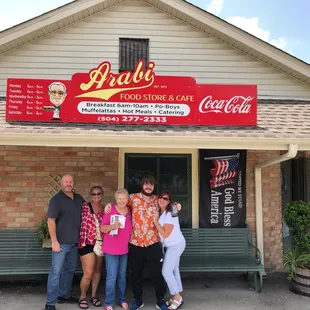 a group of people standing in front of a restaurant