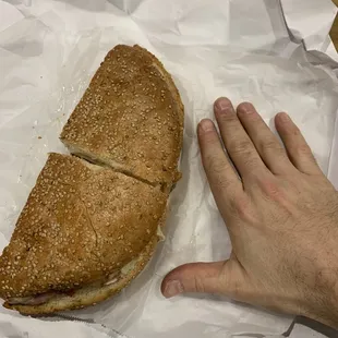 a hand reaching for a sandwich