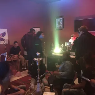 a group of people sitting around a hookah lounge