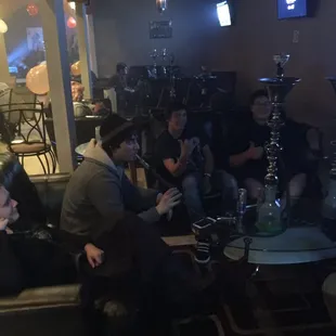 a group of people sitting around a hookah lounge