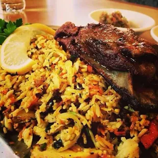 a plate of rice with meat and vegetables