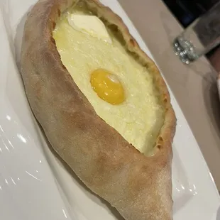 ADJARIAN KHACHAPURI- Authentic Georgian style cheese bread- boat-shaped loaf filled with a soft baked egg and a slice of butter