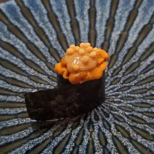 a sushi dish on a plate with chopsticks