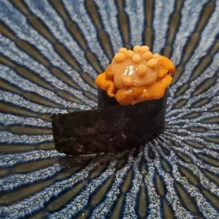 a sushi dish on a plate with chopsticks