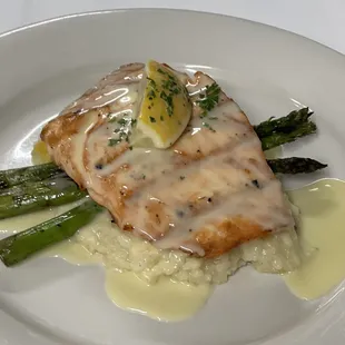 Salmon over risoto, asparagus and lemon sauce topping