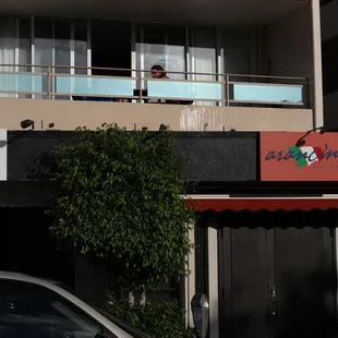 a man standing on the balcony of a building
