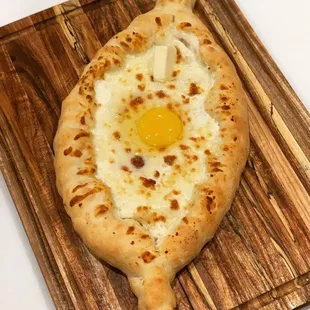 a baked egg on a wooden cutting board