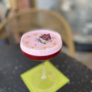 a pink cocktail in a coupe glass