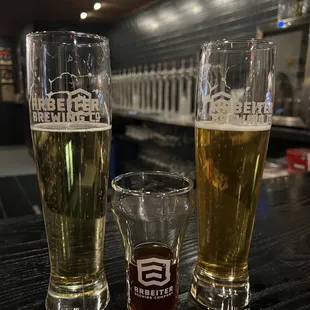 three glasses of beer on a bar