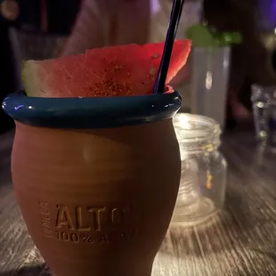 a watermelon in a cup with a straw