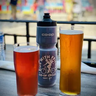 two glasses of beer and a water bottle