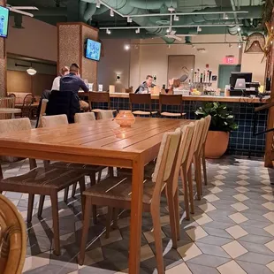 a restaurant with a large wooden table and chairs